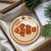 A round ornament with the word "CLOWNFISH" printed on it, featuring an illustration of an orange clownfish.