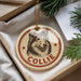 A round ornament with a dog's head and the name "COLLIE" printed on it, hanging from a string.