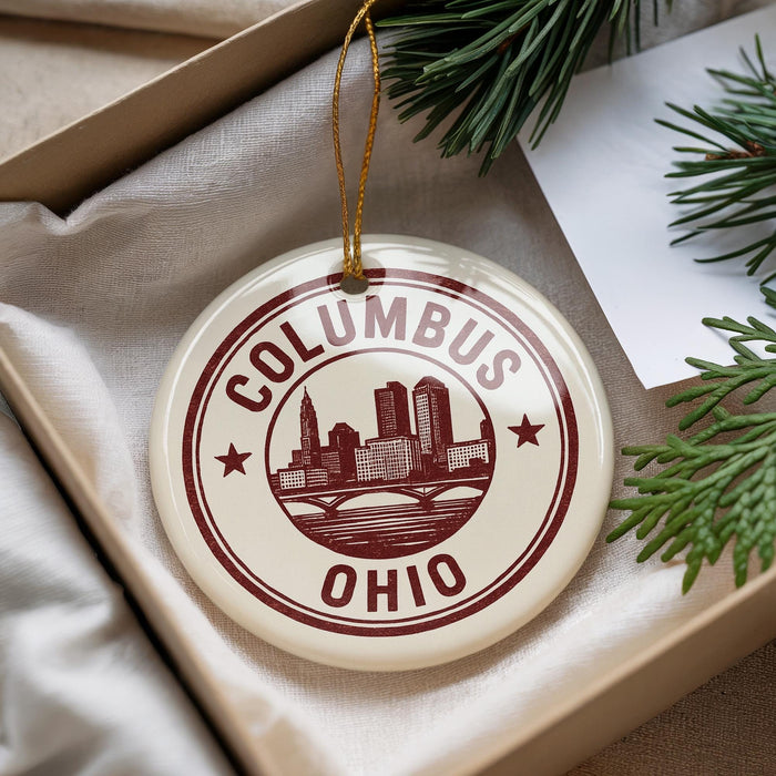 A decorative ornament with the text "COLUMBUS OHIO" printed on it, hanging from a string.