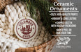 Ceramic ornaments, specifically a ceramic ornament with the text "Columbus Ohio" on it, are displayed in a basket with pine branches.