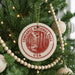 A Christmas tree decorated with ornaments, including a circular ornament with the text "CONGAREE NATIONAL PARK USA" and a tree with white beads.