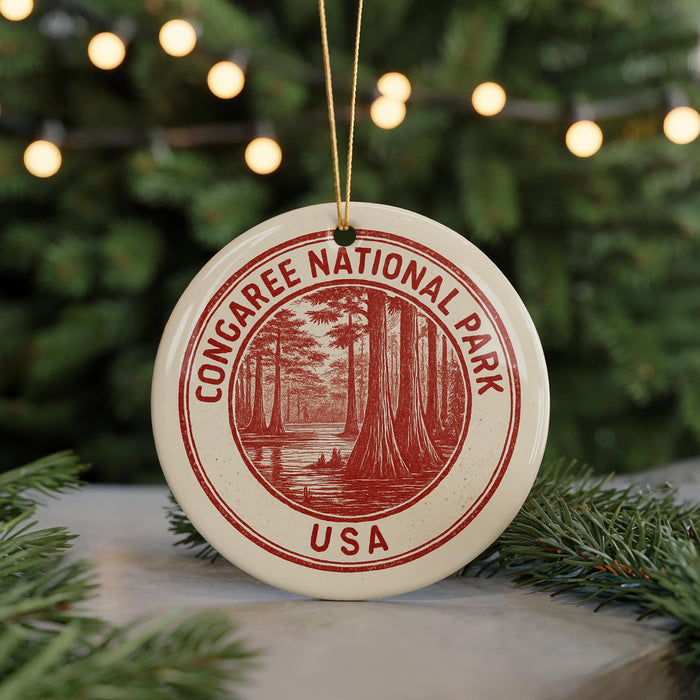 A red and white ornament with the text "CONGAREE NATIONAL PARK USA" and an illustration of a forest, hanging from a string.