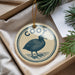 A round ornament with a bird image and the word "Coot" printed on it, hanging from a string.