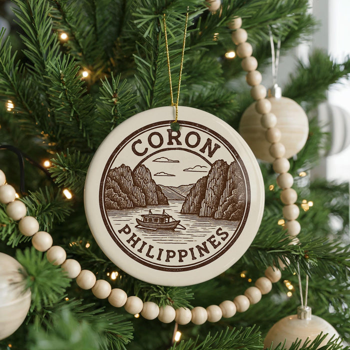 A Christmas tree decorated with ornaments, including a circular ornament with the text "CORON PHILIPPINES" and a boat illustration.