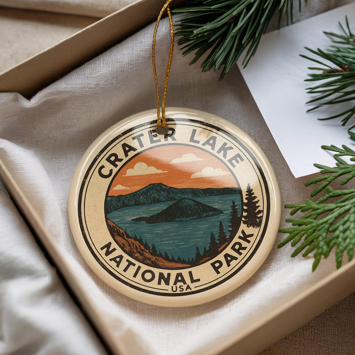 A circular ornament with the text "Crater Lake National Park" and an illustration of a lake surrounded by mountains, hanging from a string.