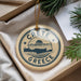 A circular ornament with the text "CRETE GREECE" and a graphic of a Greek island, hanging from a string.
