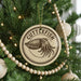 A Christmas tree decorated with ornaments, including a circular ornament with an image of an octopus and the text "CUTTLEFISH" on it.