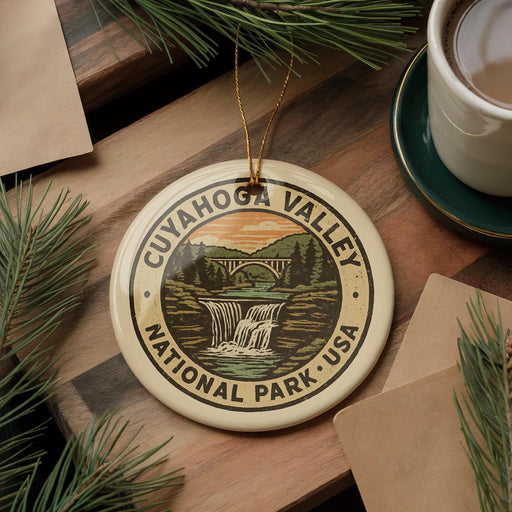 A decorative ornament featuring the image of the Cuyahoga Valley National Park in the United States, surrounded by pine branches and a cup of coffee.