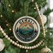 A Christmas tree decorated with ornaments, including a circular ornament with the text "DENALI NATIONAL PARK PARK U.S.A."