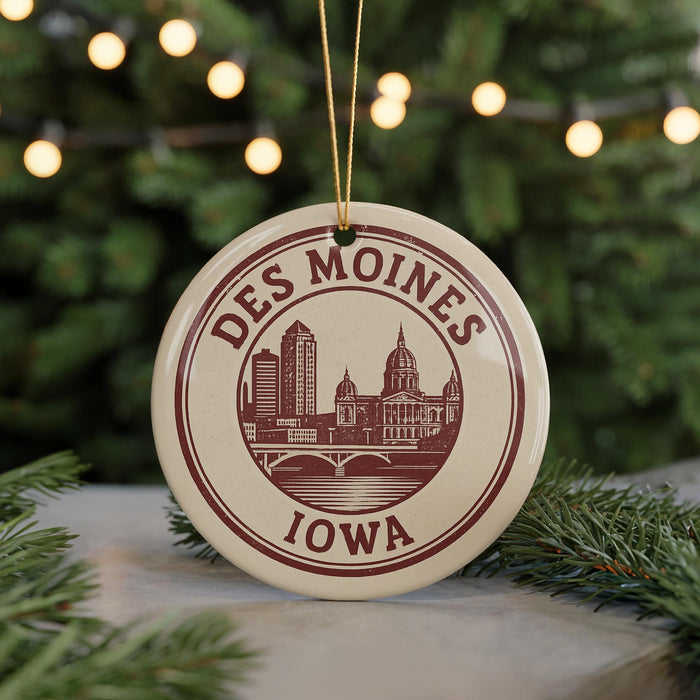 A circular ornament with the text "DES MOINES IOWA" and an illustration of a city skyline, hanging from a string.