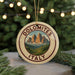 A circular ornament with the text "DOLOMITES ITALY" and a mountain landscape design, hanging from a string.