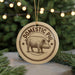 A round ornament with the text "DOMESTIC PIG" and an illustration of a pig is displayed in front of a Christmas tree with twinkling lights.