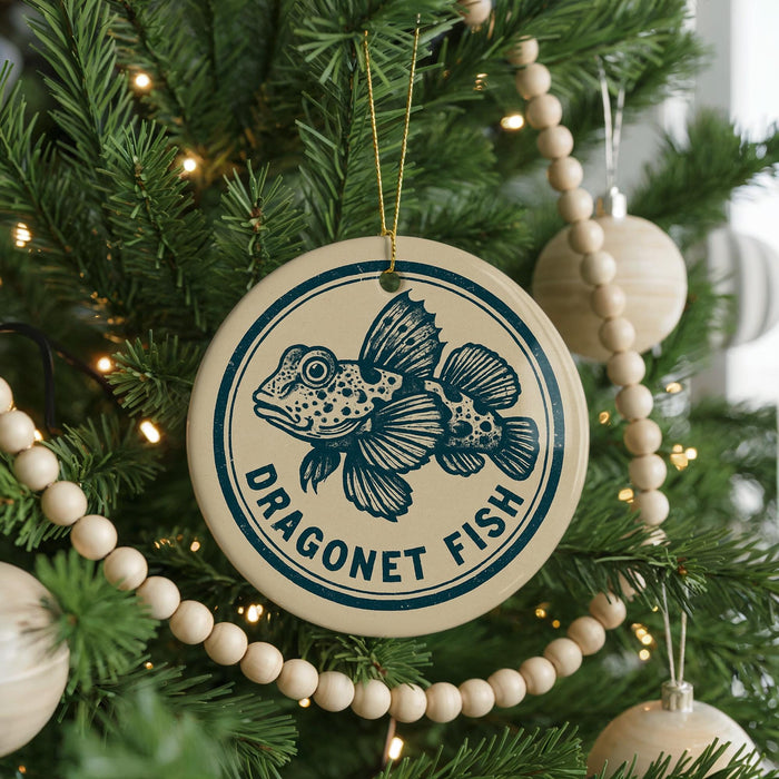 A Christmas tree decorated with ornaments, including a circular ornament with a fish design and the text "DRAGONET FISH" on it.
