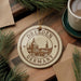 A circular ornament with the text "Dresden Germany" and an illustration of a cityscape, hanging on a wooden surface.