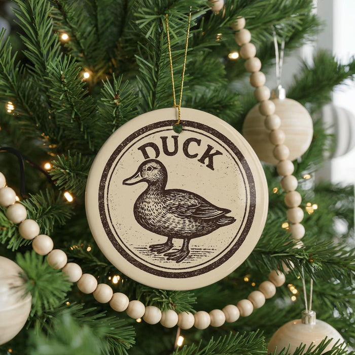 A Christmas tree decorated with ornaments, including a circular ornament with a duck design and a string of wooden beads.