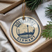 A circular ornament with the text "DÜSSELLDORF GERMANY" printed on it, hanging from a string.