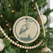 A Christmas tree decorated with ornaments, including a circular ornament featuring a bird silhouette.