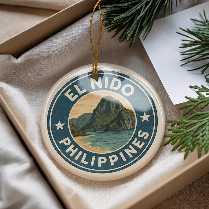 A round ornament with the text "EL NIDO PHILIPPINES" and a mountain landscape design, hanging from a string.