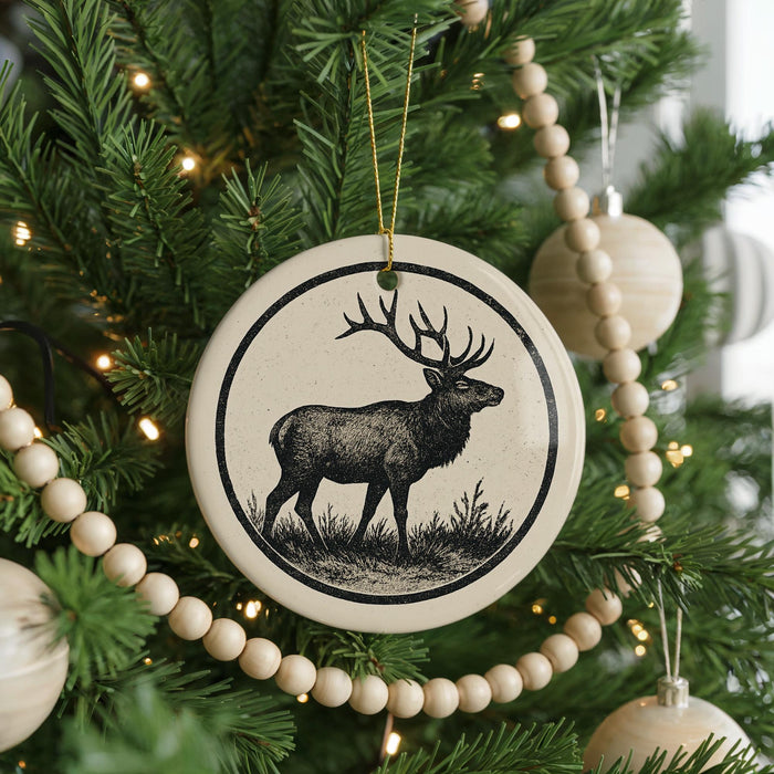 A Christmas tree decorated with ornaments, including a deer ornament in the center.