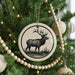 A Christmas tree decorated with ornaments, including a deer ornament in the center.