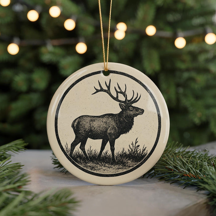 A ceramic ornament featuring a deer silhouette is displayed against a blurred background of a Christmas tree with twinkling lights.