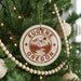 A Christmas tree decorated with ornaments, including a circular ornament with the text "EUGENE OREGON USA" and a mountain landscape design.
