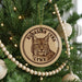A Christmas tree decorated with ornaments, including a circular ornament featuring a picture of a lynx.
