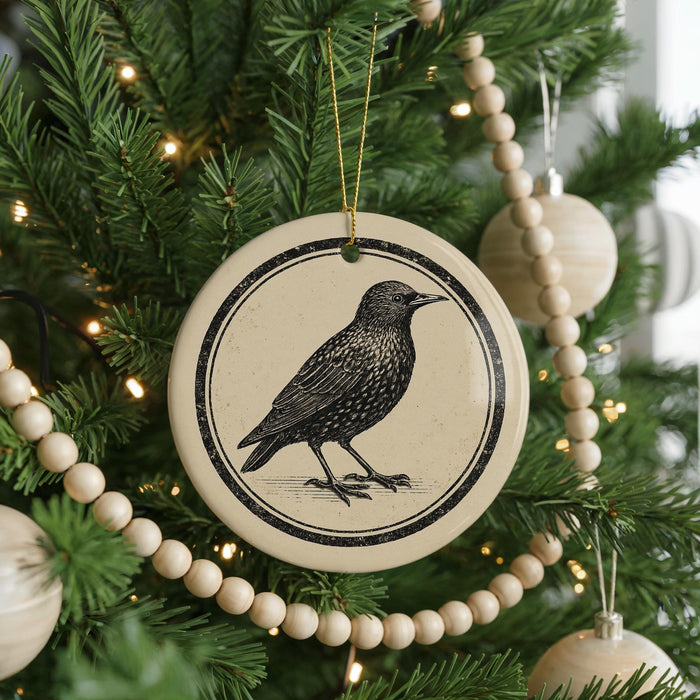A Christmas tree decorated with ornaments, including a circular ornament featuring a black bird illustration.