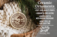 Ceramic ornaments, featuring a round ornament with a tree design and text, hanging from a wicker basket with pine branches.