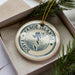 A circular ornament with the text "Faroe Islands" and a map of the Faroe Islands, surrounded by pine branches.