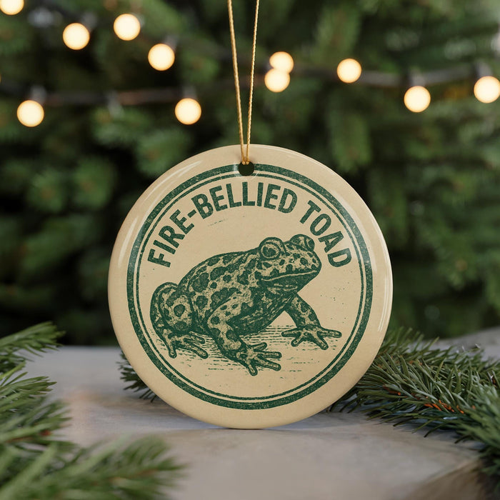 A circular ornament featuring a green frog with the text "FIRE-BELLIED TOAD" on it, hanging from a string.