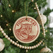 A Christmas tree decorated with ornaments, including a circular ornament with a cat image and the text "FISHING CAT" on it.