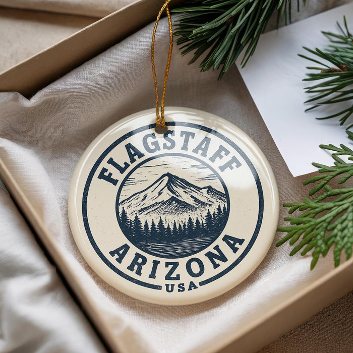 A circular ornament with the text "FLAGSTAFF ARIZONA USA" printed on it, hanging from a string.