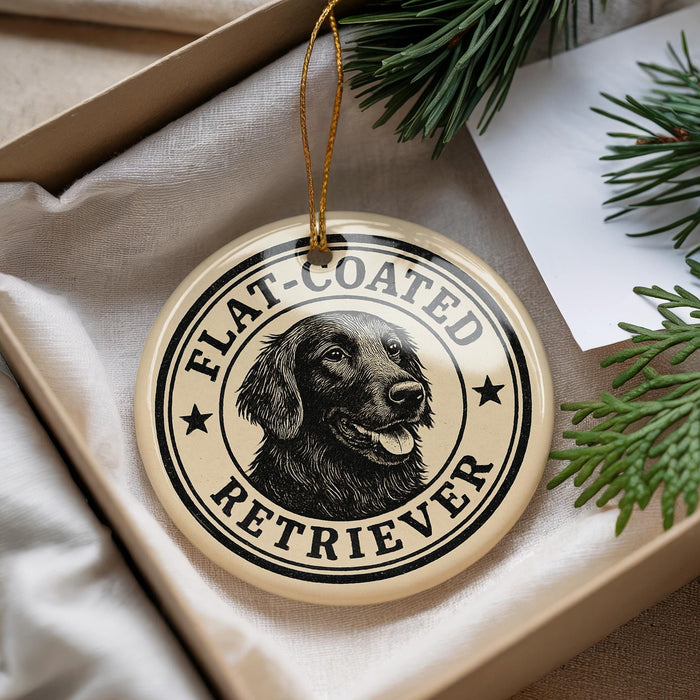 A round ornament with a black and white illustration of a retriever dog, surrounded by text that reads "FLAT-COATED RETRIEVER".