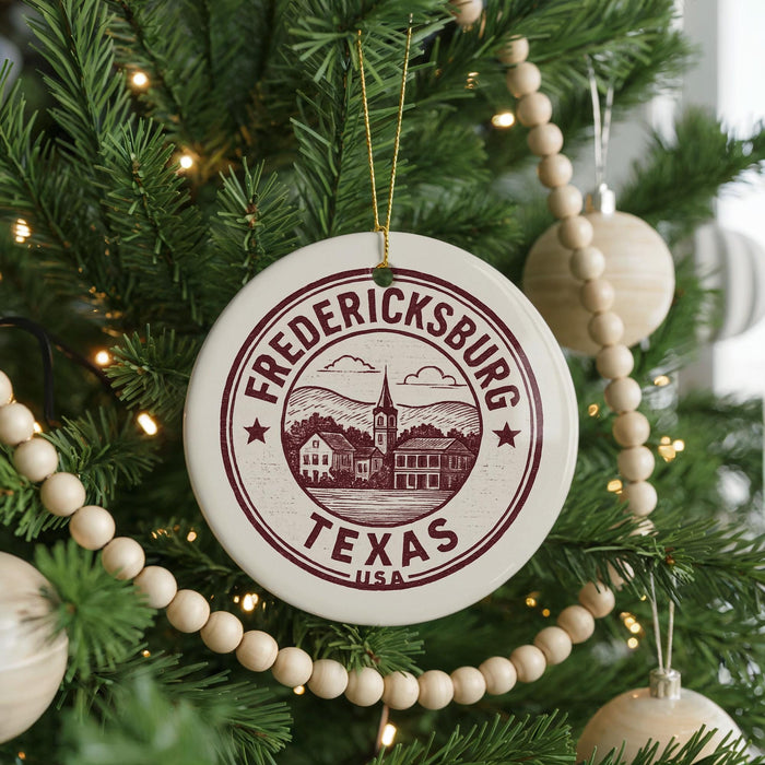 A Christmas tree decorated with ornaments, including a circular ornament with the text "FREDERICKSBURG TEXAS USA" and a wooden bead decoration.