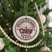 A Christmas tree decorated with ornaments, including a circular ornament with the text "FREDERICKSBURG TEXAS USA" and a wooden bead decoration.