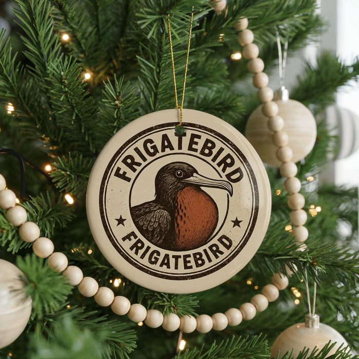 A circular ornament on a Christmas tree, featuring a bird illustration and the text "Frigatebird" in a decorative font.