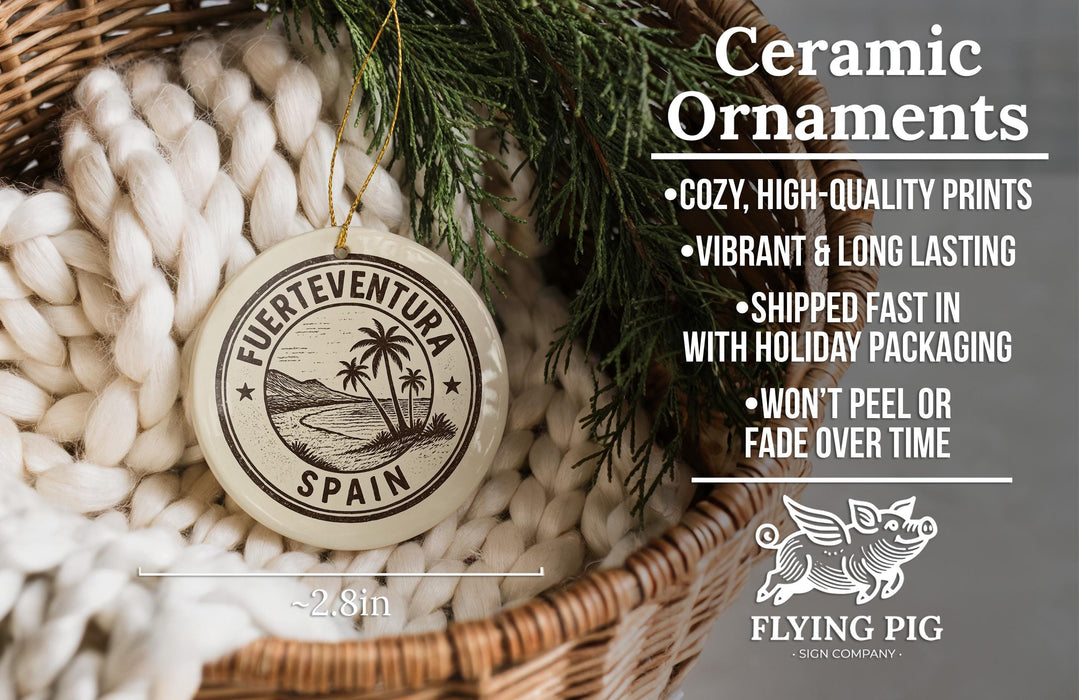 Ceramic ornaments, featuring a round ornament with a palm tree design and text, hanging from a wicker basket with greenery.