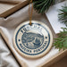 A circular ornament with the text "FUNCHAL MADEIRA PORTUGAL" printed on it, hanging from a string.