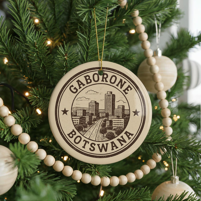 A Christmas tree decorated with ornaments, including a circular ornament with the text "GABORONE BOTSWANA" and a cityscape design.