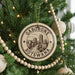 A Christmas tree decorated with ornaments, including a circular ornament with the text "GABORONE BOTSWANA" and a cityscape design.