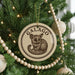 A Christmas tree decorated with ornaments, including a circular ornament with a picture of a small animal, likely a koala, and the word "GALAGO" written on it.