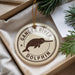 A circular ornament with the text "Ganges River Dolphin" printed on it, hanging from a string.