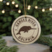 A circular ornament with the text "Ganges River Dolphin" and a graphic of a dolphin is displayed on a Christmas tree.