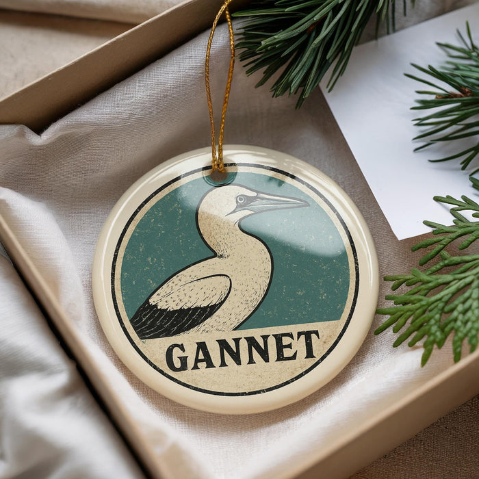 A circular ornament with a bird image and the word "GANNET" printed on it, hanging from a string.