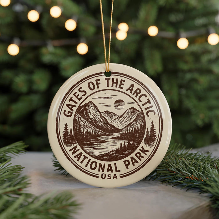 A circular ornament with the text "GATES OF THE ARCTIC NATIONAL PARK USA" printed on it, surrounded by pine branches and lights.