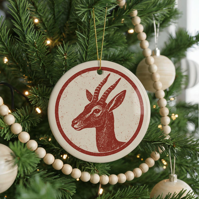 A Christmas tree decorated with ornaments, including a red and white ornament featuring a deer head.
