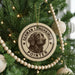 A round ornament on a Christmas tree featuring a German Longhaired Pointer dog.