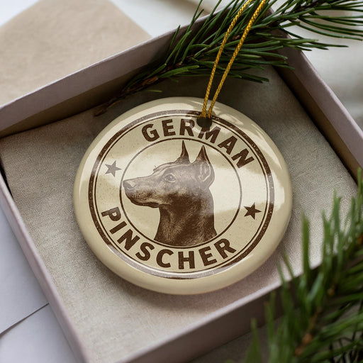 A circular ornament with the text "GERMAN PINSCHER" printed on it, featuring a close-up image of a German Pinscher dog.