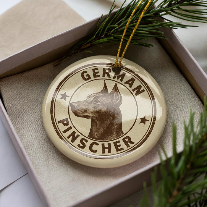 A circular ornament with the text "GERMAN PINSCHER" printed on it, featuring a close-up image of a German Pinscher dog.